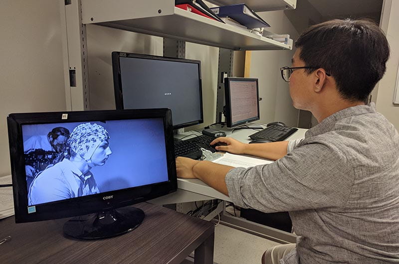 Research looking at monitor, running an EEG test session.